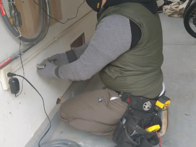 Electrician performing outlet wiring in a Brookfield garage
